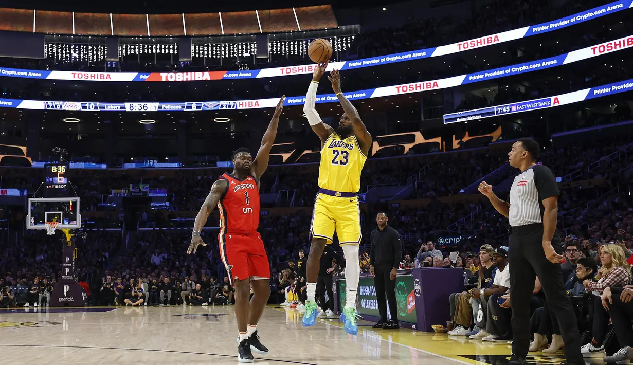 Pebasket Los Angeles Lakers, LeBron James melakukan lemparan three poin dibayangi pebasket New Orleans Pelicans, Zion Williamson untuk mencetak 50.002 poin dalam sejarah NBA di Crypto Arena, Los Angeles, Rabu (05/03/2025) pagi WIB. (AFP/Getty Images/Ronald Martinez)