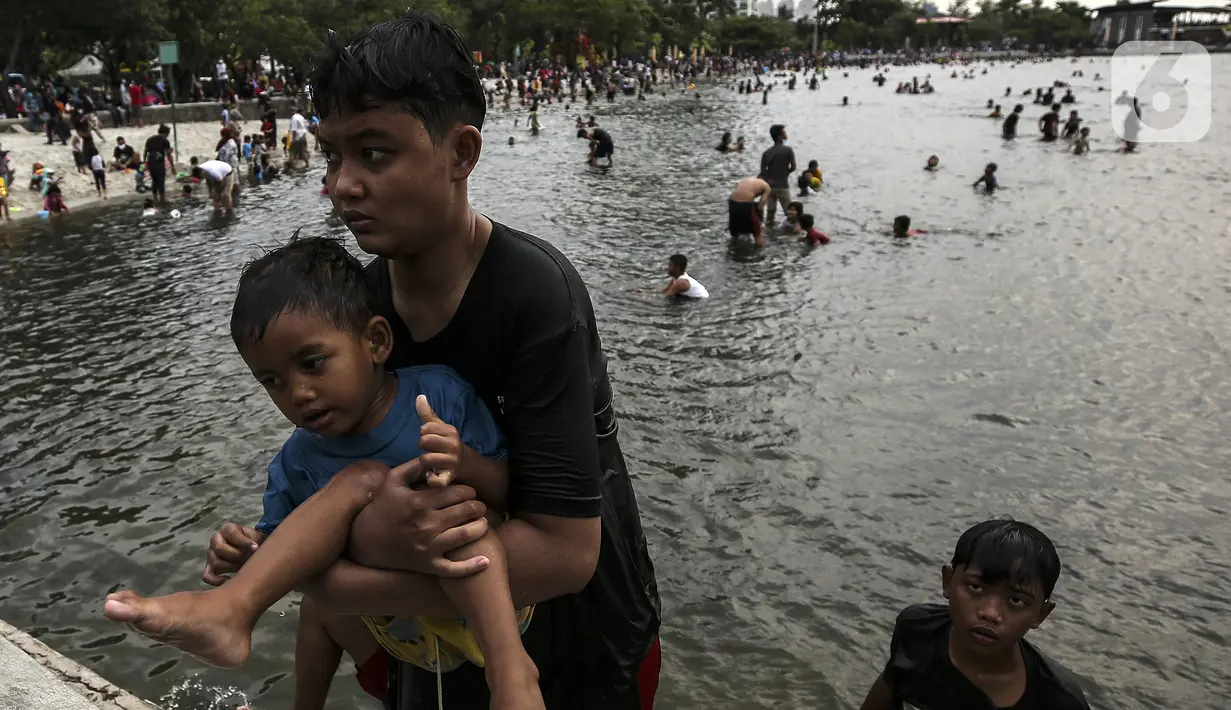 Pengunjung berenang di Pantai Karnaval Ancol, Jakarta, Jumat (14/5/2021). Ancol dibuka khusus bagi warga ber-KTP DKI Jakarta dan membatasi jumlah wisatawan dengan kapasitas 30 persen. (Liputan6.com/Johan Tallo)