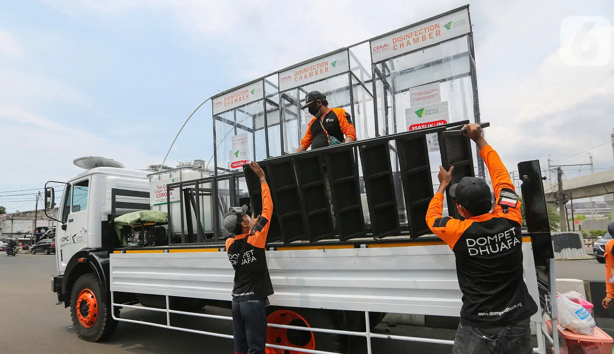 Relawan Dompet Dhuafa memasang tangga untuk masyarakat yang akan menggunakan disinfektan chamber di CheCk Point PSBB, perbatasan Jakarta - Tangsel, Pasar Jumat, Kamis (16/4/2020). Keberadaan bilik tersebut untuk memutus rantai penyebaran Corona COVID-19. (Liputan6.com/Fery Pradolo)