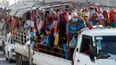 Para pekerja menaiki mobil bak terbuka sebagai transportasi harian mereka pulang ke rumah dari tempat kerja di sebuah pabrik di dekat desa Trapang Anchanh, di luar Phnom Penh, Kamboja (27/10). (AP Photo/Heng Sinith)