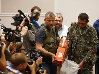 Salah satu anggota kelompok separatis pro-Rusia menunjukkan kotak hitam pesawat Malaysia Airlines MH-17 di Donetsk, (22/7/2014). (REUTERS/Maxim Zmeyev)