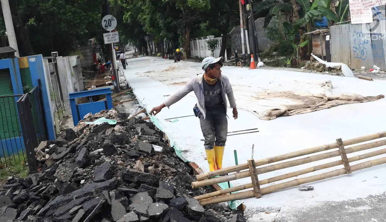 Pekerja menyelesaikan pembetonan Jalan Pejaten Raya di Jakarta Selatan (22/11). Proyek pembetonan dan peninggian badan jalan ini guna mengantisipasi banjir yang kerap terjadi di kawasan tersebut. (Liputan6.com/Immanuel Antonius)