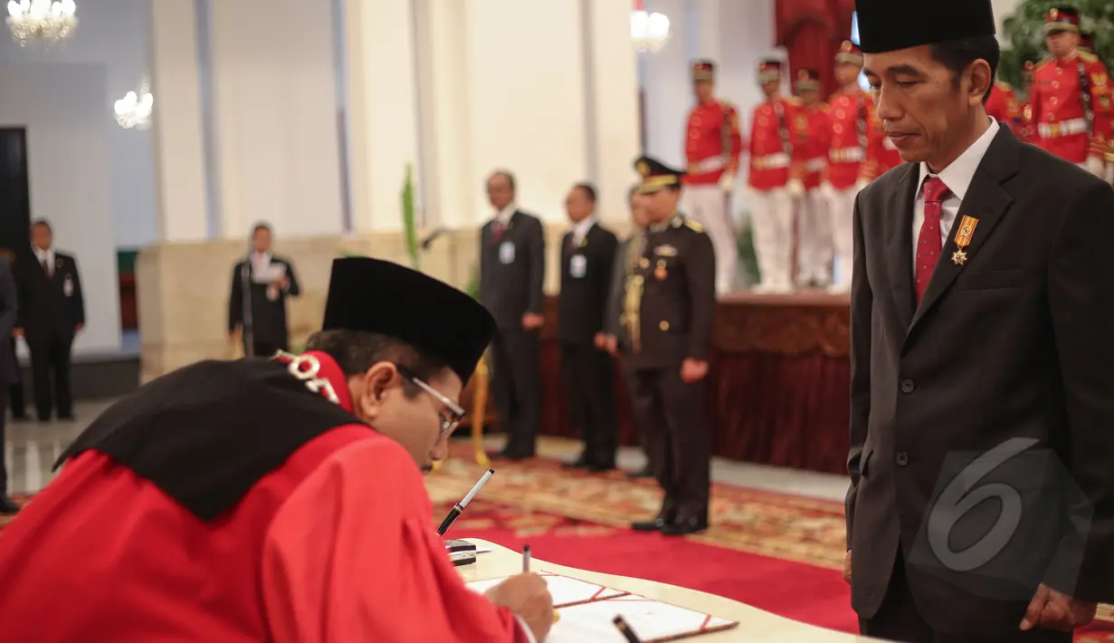 Manahan Malontige Pardamean Sitompul menandatangani surat pelantikan dirinya sebagai Hakim Konstitusi di Istana Negara disaksikan oleh Presiden Jokowi, Jakarta, Selasa (28/4/2015). (Liputan6.com/ Faizal Fanani)
