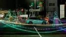 Pengunjung naik kendaraan mereka ke "The Candy Cane Lane Holiday Light Drive Through Experience" yang menampilkan hanya kurang dari satu kilometer lampu Natal dan dekorasi di atap Pusat Perbelanjaan Pavillion di Durban, Afrika Selatan (14/12/2021). (AFP/Rajesh Jayantilal)