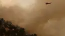Sebuah helikopter menurunkan air untuk mengatasi kebakaran di Mariposa, California (19/7). Akibat musibah ini ratusan orang telah dievakuasi. (Justin Sullivan/Getty Images/AFP)