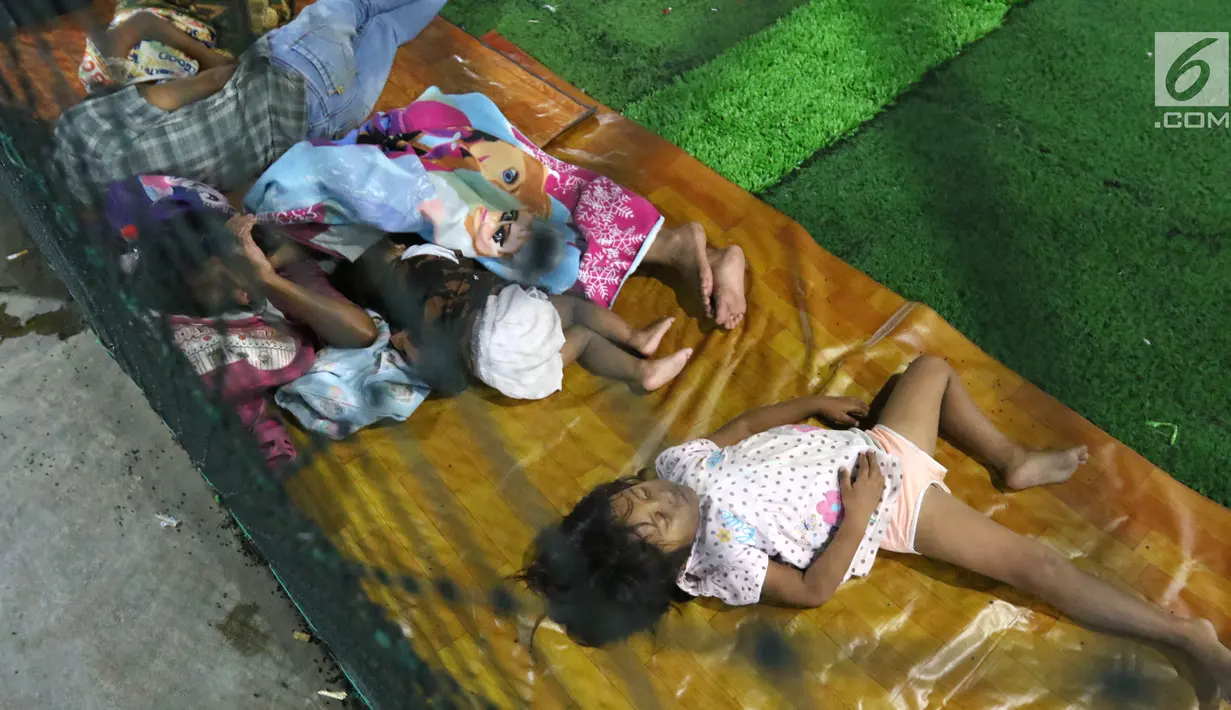 Anak-anak korban Tsunami Anyer mengungsi di lapangan futsal Labuan, Banten, Minggu (23/12). Tsunami yang menerjang wilayah Selat Sunda memilih warga mengungsi sejak siang hari. (Liputan6.com/Angga Yuniar)