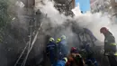 Petugas pemadam kebakaran bekerja setelah sebuah pesawat tak berawak menghantam gedung-gedung di Kyiv, Ukraina, Senin (17/10/2022).   Pesawat tak berawak menghantam sejumlah gedung ibu kota Ukraina pada Senin pagi ledakan tesebut menggema di seluruh Kyiv dan menimbulkan kepanikan sehingga orang-orang berlarian ke lokasi yang aman.  (AP Photo/Roman Hrytsyna)