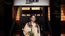 Christinna Kuan tampil youthful dengan rambut kepang kecil di kedua sisi dan makeup glowy berkilau. Ia terlihat mengenakan jaket puffer hijau mint bergaris oranye, dress mesh kuning, tas suede hijau zaitun, dan sepatu boots high-top motif [dok. Onitsuka Tiger]