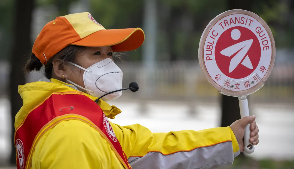 <p>Seorang penjaga persimpangan yang mengenakan masker berdiri di persimpangan di Beijing, Rabu (11/5/2022). Shanghai pada Rabu menegaskan kembali akan mempertahankan pendekatan &ldquo;nol-COVID&rdquo; pengendalian pandemi, sehari setelah kepala Organisasi Kesehatan Dunia (WHO) menyatakan kebijakan itu tidak berkelanjutan dan mendesak China mengubah strategi. (AP Photo/Mark Schiefelbein)</p>