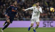 Gelandang Real Madrid, Marco Asensio, berebut bola dengan gelandang Valencia, Daniel Parejo, pada laga La Liga di Stadion Santiago Bernabeu, Madrid, Sabtu (1/12). Madrid menang 2-0 atas Valencia. (AFP/Oscar Del Pozo)