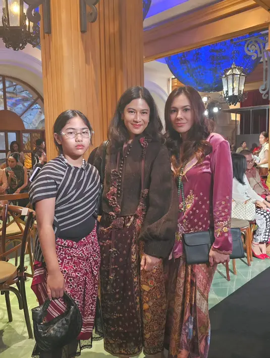 Dian Sastro kenakan atasan velvet bersiluet kebaya dengan lengan puffy yang oversized. Dipadu dengan kain Batik yang dililit longgar dan pantofel heels hitam [@wulanguritno]
