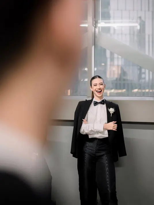 Yuki tampil maskulin namun tetap terlihat cantik dengan mengenakan kemeja putih serta celana dan jas hitam dengan dasi kupu-kupu.