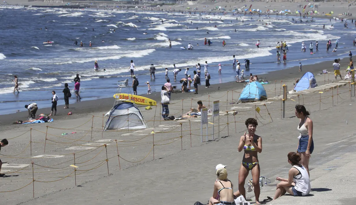 Orang-orang menikmati Pantai Shonan untuk menyejukkan diri dari teriknya musim panas di Fujisawa, dekat Tokyo, Selasa, (11/8/2020). (AP / Koji Sasahara)