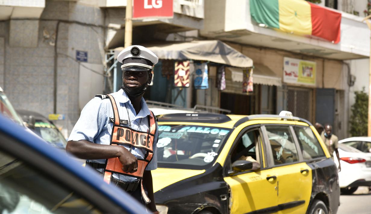Bendera nasional Senegal tergantung dari balkon di jalan sibuk Dakar (4/2/2022). Senegal akan bertanding melawan Mesir pada babak final Piala Afrika 2021 di Paul Biya stadium, Senin (7/2/2022) dini hari WIB besok. (AFP/Seyllou)