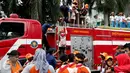 Petugas membantu anak-anak peserta acara Madrasah Siaga Bencana menaiki mobil pemadam kebakaran di hari bebas kendaraan bermotor di kawasan Thamrin, Jakarta, Minggu (22/1). (Liputan6.com/Johan Tallo)