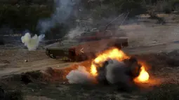 Militan Palestina menembaki tank selama latihan militer yang diselenggarakan oleh faksi militer di Rafah, Jalur Gaza selatan, Rabu (29/12/2021). (AP Photo/Adel Hana)