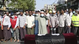 Warga salat di samping jenazah wanita Muslim yang terbunuh dalam demonstrasi saat upacara pemakamannya di Mandalay, Myanmar, Senin (1/3/2021). Massa yang memberontak kembali ke jalan-jalan di kota terbesar Myanmar, Yangon pada hari Senin. (AP Photo)
