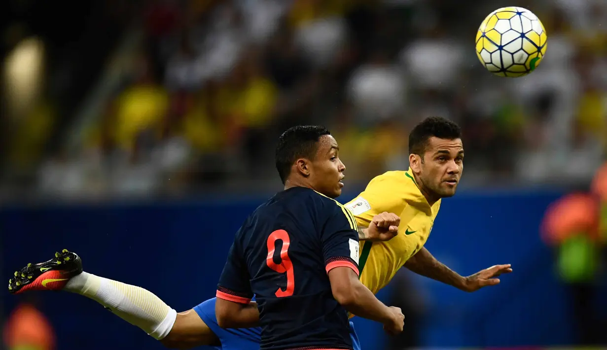 Aksi Dani Alves menghalau bola dari kejaran pemain Kolombia, Luis Fernando Muriel pada kualifikasi Piala Dunia 2018 zona Conmebol di Manaus, Brasil, (7/92016) WIB. (AFP/Chrisophe Simon)