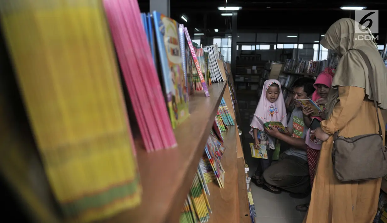 Pengunjung mendampingi anaknya memilih buku di Pasar Kenari, Jakarta Pusat, Selasa (30/4/2019). Pasar buku itu merupakan pasar buku pertama di Jakarta yang didirikan untuk menyediakan buku-buku berharga yang murah alias terjangkau dan dikelola PD Pasar Jaya. (merdeka.com/Iqbal S. Nugroho)