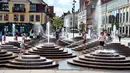 Anak-anak mendinginkan diri dengan bermain di air mancur saat gelombang panas menerjang Eropa di Toldbod Plads, Aalborg, Denmark, Rabu (24/7/2019). Eropa Barat dilanda gelombang panas yang hebat minggu ini. (Henning Bagger/Ritzau Scanpix via AP)