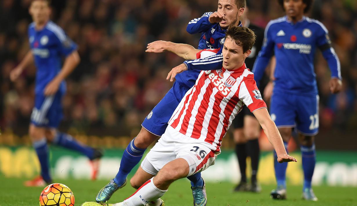 Pemain Stoke City, Philipp Wollscheid, berebut bola dengan pemain Chelsea, Eden Hazard, pada lanjutan Liga Premier Inggris di Stadion Britannia, Stoke, Minggu (8/11/2015) dini hari WIB.  (AFP Photo/Paul Ellis)