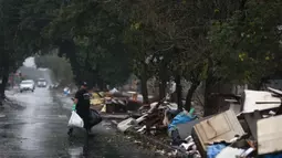 Seorang pria mengangkut sampah dari rumahnya yang dilanda banjir di lingkungan Sarandi, salah satu wilayah yang paling parah terkena dampak hujan lebat di Porto Alegre, negara bagian Rio Grande do Sul, Brasil, pada tanggal 27 Mei 2024. (Anselmo Cunha/AFP)
