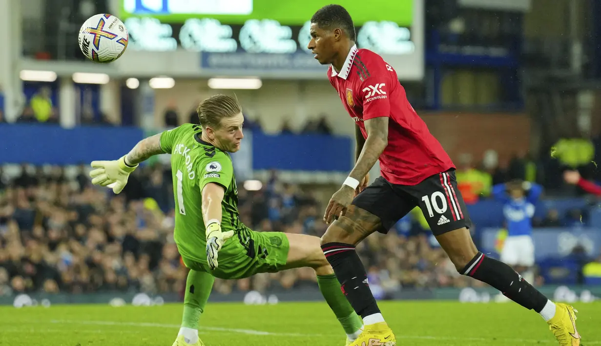 <p>Penyerang Manchester United, Marcus Rashford menggiring bola melewati kiper Everton Jordan Pickford untuk mencetak gol yang dianulir dalam pertandingan lanjutan Liga Inggris di Goodison Park, di Liverpool, Inggris, Senin (10/10/2022). Kemenangan ini membawa Man United naik ke posisi lima dengan koleksi lima poin. (AP Photo/Jon Super)</p>