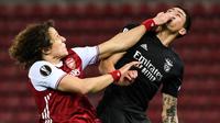 Tampak pemain Arsenal, David Luiz (kiri) berduel dengan pemain Benfica pada leg 2 babak 32 besar Liga Europa 2020/2021, Jumat (26/02/2021) dini hari WIB. (ARIS MESSINIS / AFP)