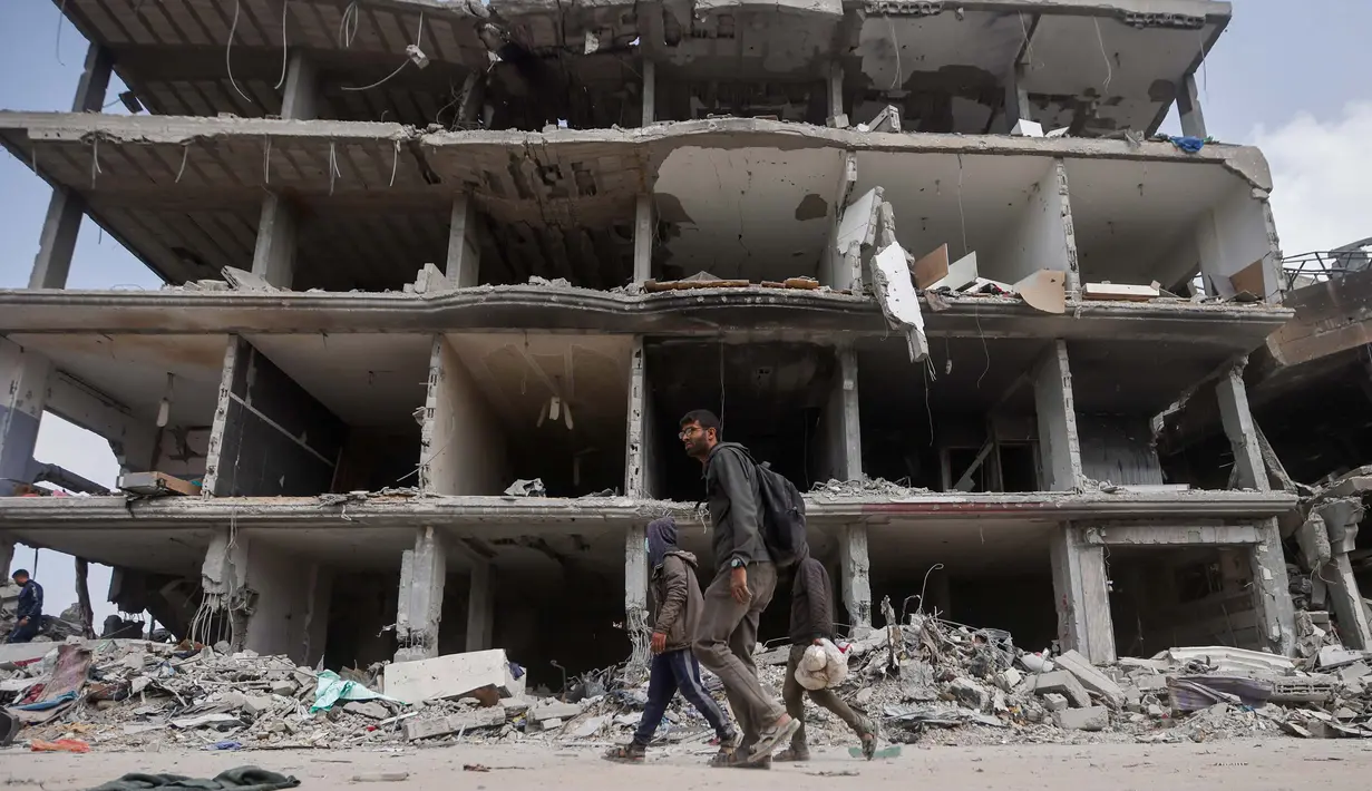 Warga Palestina berjalan di tengah kehancuran setelah pasukan Israel meninggalkan Khan Younis, Jalur Gaza, Rabu, 6 Maret 2024. (AP Photo/Mohammed Dahman)