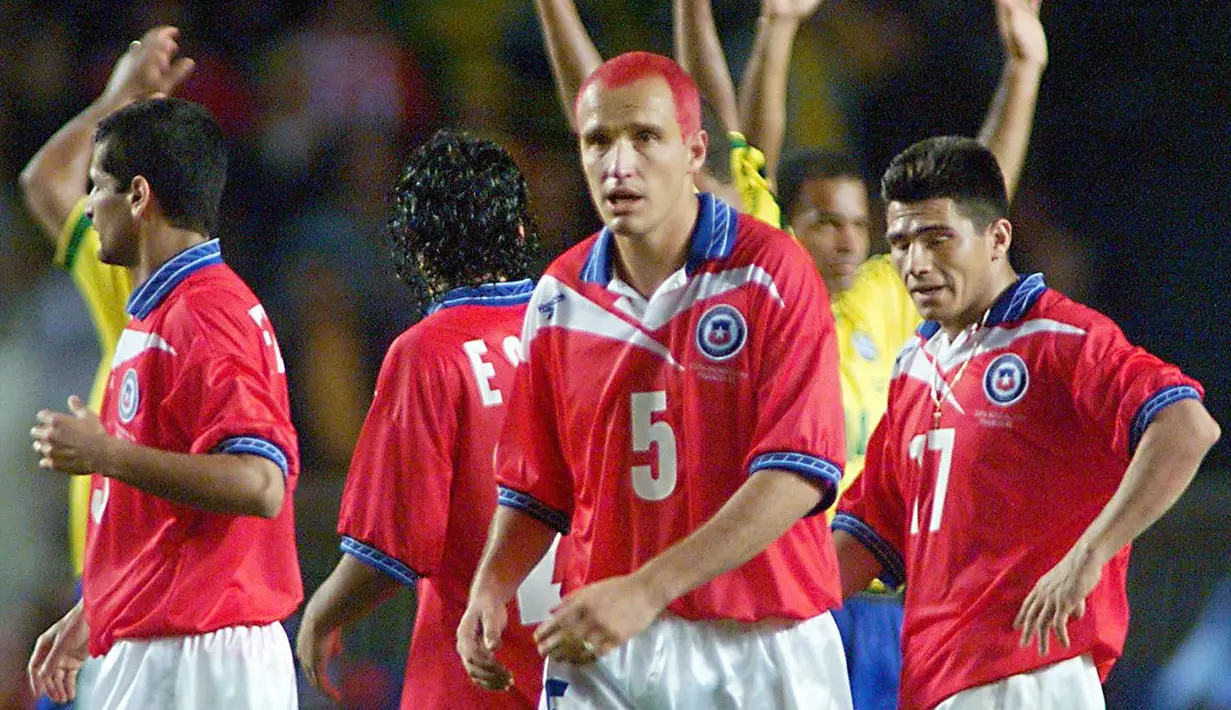 Javier Margas merupakan seorang bek berkebangsaan Chile. Pemain yang pernah membela West Ham United tersebut terkenal sering gonta-ganti warna rambutnya. Ia terlihat berambut merah pada Piala Dunia 1998, senada dengan warna jersey negaranya. (AFP/Thomas Coex)