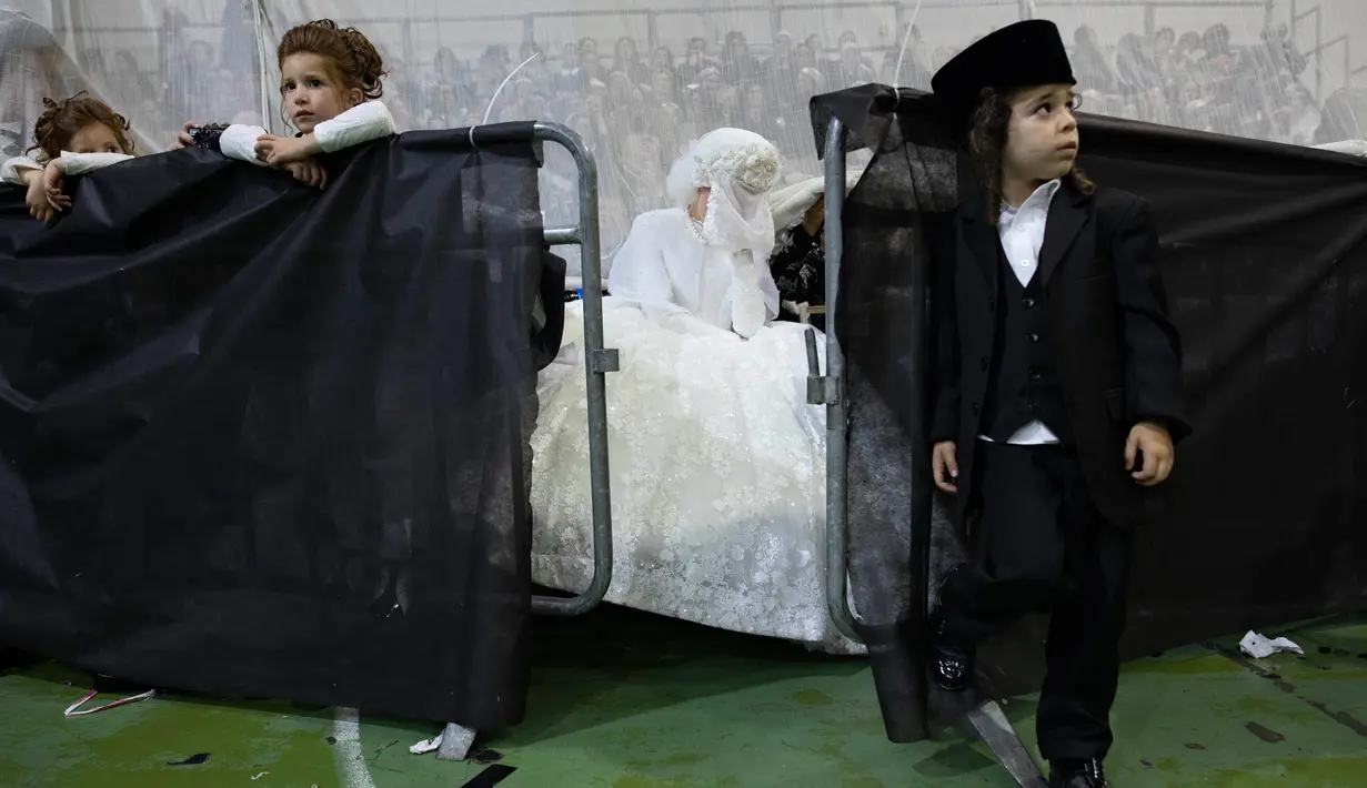 Pengantin Yahudi ultra-ortodoks Hannah Halbershtam memasuki bagian pria saat melangsungkan upacara pernikahan di kota ultra-ortodoks Bnei Brak, Israel, Selasa (20/8/2019. (AP Photo/Oded Balilty)