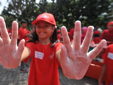 Siswa SD memperlihatkan tangannya saat memperingati Hari Cuci Tangan se-Dunia di halaman Kantor Walikota Jakarta Barat, Jakarta (15/10/2015). Aksi cuci tangan untuk memberi pendidikan kebersihan dan kesehatan sejak usia dini. (Liputan6.com/Gempur M Surya)