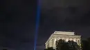 Cahaya biru terlihat saat penghormatan ringan untuk serangan 9/11 di Pentagon yang berada di samping Lincoln Memorial di Washington, DC (11/9/2020). Pertunjukan tersebut adalah bagian dari peringatan skala kecil tahun ini karena pandemi virus corona. (Tasos Katopodis / Getty Images / AFP)