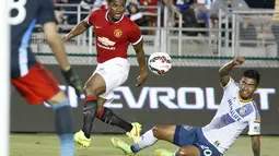Gelandang Manchester United, Antonio Valenica (kiri) mencoba melewati hadangan pemain LA Galaxy, AJ DeLaGarza, saat berlaga di Rose Bowl, Kalifornia, (23/7/2014). (REUTERS/Lucy Nicholson)