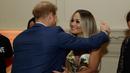 Pangeran Harry memeluk penyanyi Rita Ora sebelum konser yang diadakan badan amal Sentebale di Hampton Court Palace, London (11/6/2019). Rita Ora tampil seksi mengenakan gaun mini glamor dengan pola kerubin dengan sandal bertali. (AP Photo/Matt Dunham)