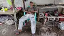 Seorang warga tengah tertidur lelap di bengkel las di kawasan Kampung Nelayan Cilincing, Jakarta Utara, Rabu (8/2). (Fery Pradolo/Liputan6.com)