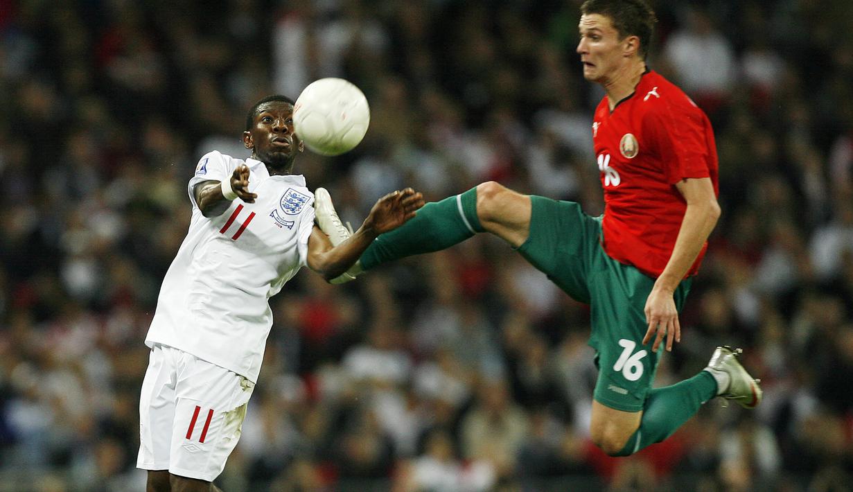 Gelandang Timnas Inggris, Shaun Wright-Phillips (kiri) berebut bola dengan bek Belarusia, Igor Shitov pada laga kualifikasi Piala Dunia 2010 Grup 6 di Wembley Stadium, London (14/10/2009). Hingga pensiun pada Agustus 2019, Shaun Wright-Phillips total tampil dalam 36 laga bersama Timnas Inggris dengan torehan 6 gol dan 3 assist. Pada laga debutnya menghadapi Ukraina dalam sebuah laga persahabatan (18/8/2004), ia langsung mencetak satu gol dan membawa Inggris menang 3-0. (AFP/Glyn Kirk)