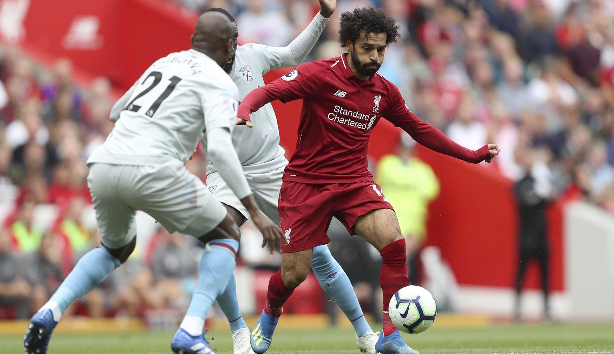 Penyerang Liverpool, Mohamed Salah, berusaha melewati pemain West Ham pada laga Premier League di Stadion Anfield, Minggu (12/8/2018). Liverpool menang 4-0 atas West Ham. (AP/David Davies)
