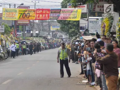 Warga sekitar Puri Cikeas bersiap menyambut iring-iringan kepergian jenazah Ani Yudhoyono menuju TMP Kalibata, Bogor, Jawa Barat, Minggu (2/6/2019). Ani Yudhoyono dimakamkan di TMP Kalibata. (Liputan6.com/Immanuel Antonius)