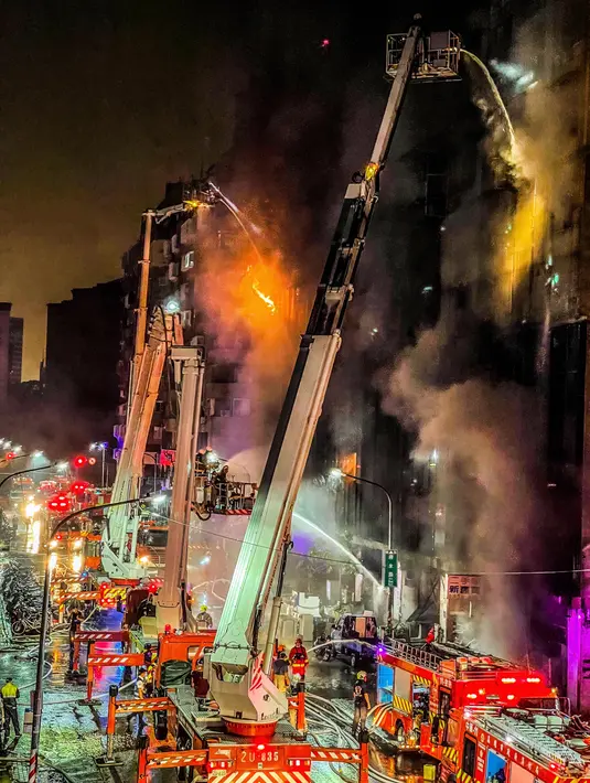 Petugas pemadam kebakaran memadamkan api di sebuah gedung di Kaohsiung, Taiwan selatan, Kamis (14/10/2021). Petugas pemadam kebakaran membutuhkan waktu lebih dari empat jam untuk memadamkan api. (EBC via AP )