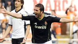 Striker Real Madrid Gonzalo Higuain merayakan gol ketiga untuk membantu Los Merengues menggulung Valencia 6-3 pada partai lanjutan La Liga di Estadio Mestalla, 23 April 2011. AFP PHOTO/PEDRO ARMESTRE