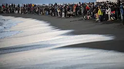 Orang-orang berkumpul di Pantai Selatan Chigasaki untuk menyaksikan matahari terbit pada Hari Tahun Baru di Prefektur Kanagawa, barat daya Tokyo (1/1/2021). (AFP/Philip Fong)