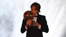 Gelandang Real Madrid, Luka Modric mencium trofi setelah memenangkan penghargaan Ballon d'Or 2018 pada malam penganugerahan di Paris, Senin (3/12). Penghargaan individu ini menjadi gelar Ballon d'Or pertama sepanjang karier Modric. (FRANCK FIFE/AFP)
