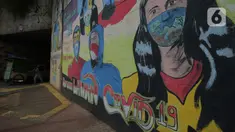 Pedagang melintas di depan mural anjuran kebiasan hidup baru dengan 3 M di Stasiun Cawang, Jakarta, Sabtu (26/12/2020). Pemerintah terus berupaya melakukan imbauan kepada warga untuk melaksanakan kebiasaan baru 3M guna memutus penyebaran virus corona (COVID-19). (merdeka.com/Imam Buhori)