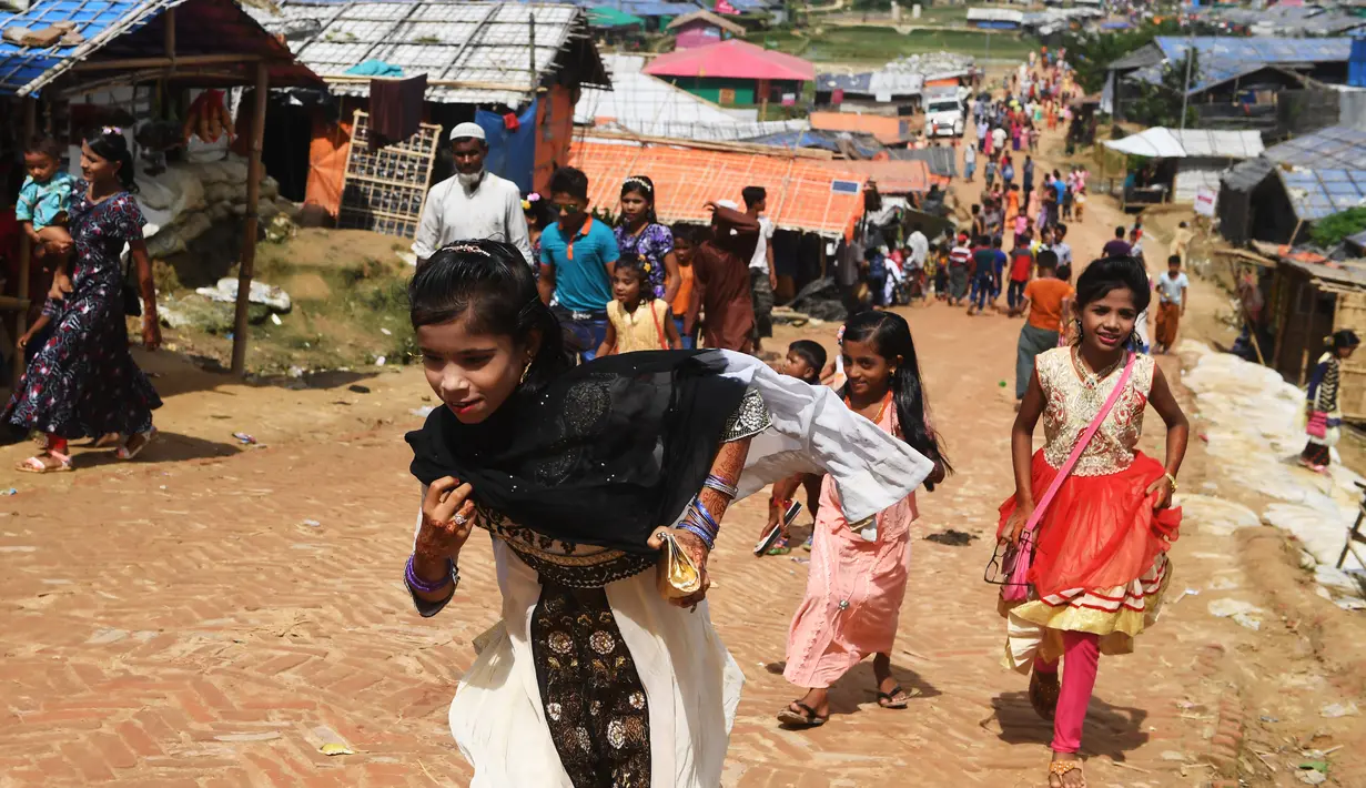 Bocah-bocah Rohingya mengenakan pakaian baru selama perayaan Idul Adha di kamp pengungsi Thangkhali, Bangladesh, Rabu (22/8). Wajah riangnya senapas dengan baju baru yang dikenakan di hari bahagia ini. (Dibyangshu SARKAR / AFP)