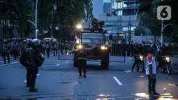 Anggota brimob memukul mundur massa aksi di kawasan Tanah Abang, Jakarta, Selasa (13/10/2020). Hingga menjelang magribh massa masih melakukan perlawan di kawasaan tersebut. (Liputan6.com/Faizal Fanani)