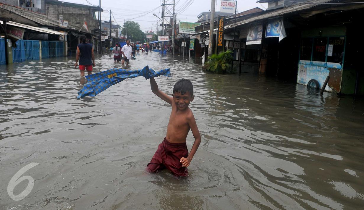 Seorang anak bergaya saat banjir melanda kawasan Rawa Buaya, Jakarta, Minggu (28/2/2016). Rawa Buaya menjadi kawasan yang mengalami banjir terparah hingga mencapai 1 meter. (Liputan6.com/Gempur M Surya)