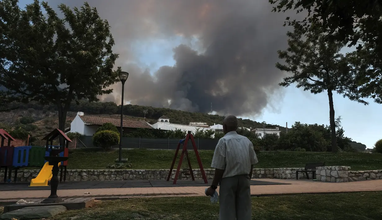 <p>Seorang pria terlihat saat api menjalar di dekat daerah perumahan di Alhaurin de la Torre, Malaga, Spanyol, Sabtu (16/7/2022). Gelombang panas yang melanda Spanyol memicu api menyebar lebih cepat dan menghambat upaya pengendalian kebakaran. (AP Photo/Gregorio Marrero)</p>