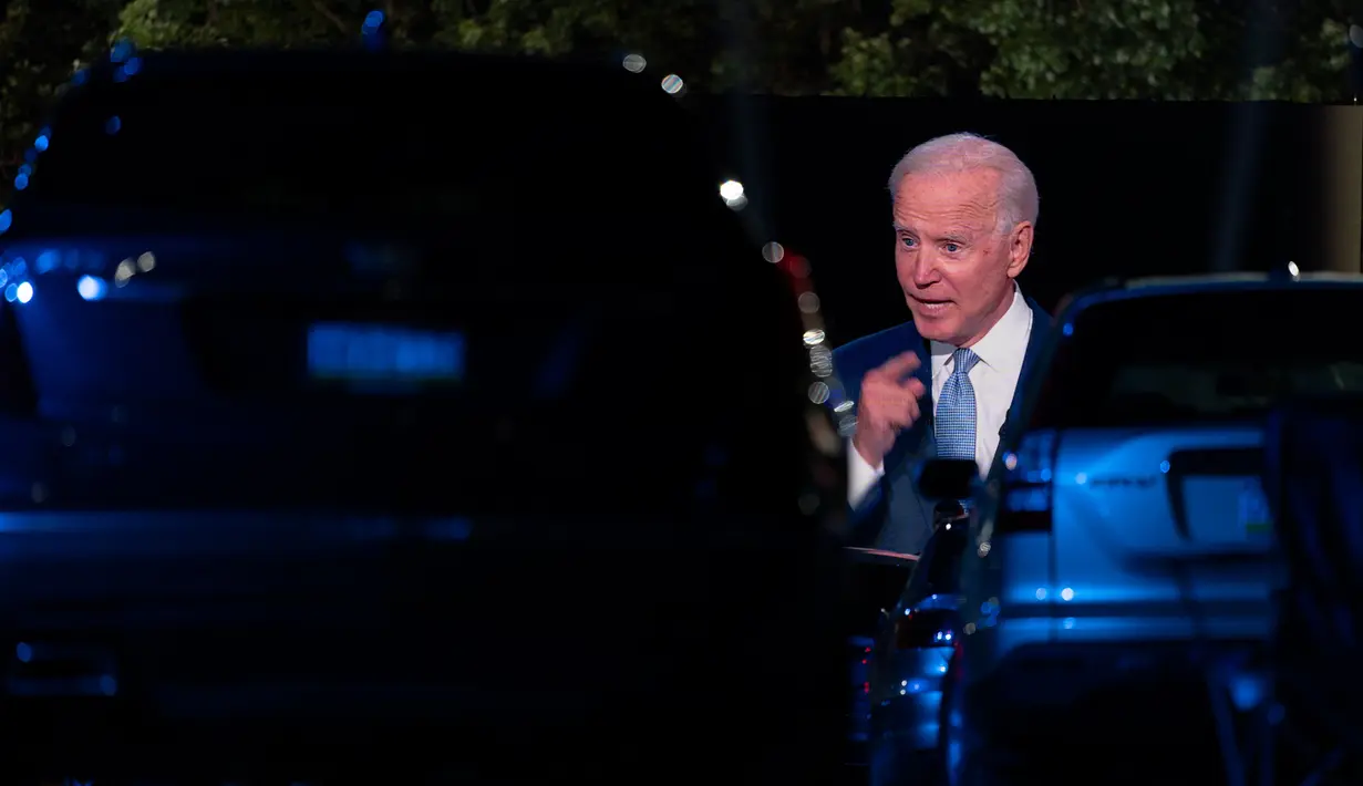 Penonton menyaksikan dari mobil mereka ketika calon presiden dari Partai Demokrat, Joe Biden, terlihat pada layar monitor, berbicara dalam kampanye secara drive-in yang diselenggarkan CNN di Moosic, Pennsylvania, Kamis (17/9/2020). (AP Photo/Carolyn Kaster)