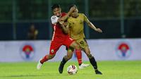 Pemain Persija Jakarta, Sandi Sute (kiri) berebut bola dengan pemain Bhayangkara Solo FC, TM Ichsan, pada laga Piala Menpora 2021 di Stadion Kanjuruhan, Malang, Rabu (31/3/2021). (Bola.com/M Iqbal Ichsan)